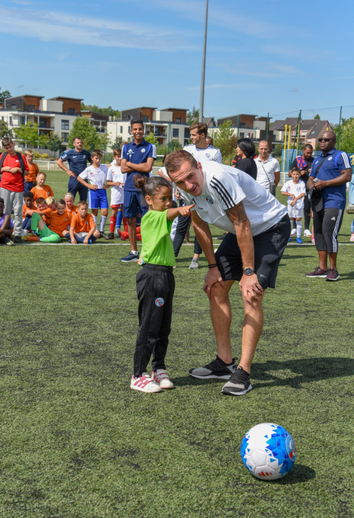 ete foot 2019, un enfant avec un joueur de foot du racing club de Strasbourg